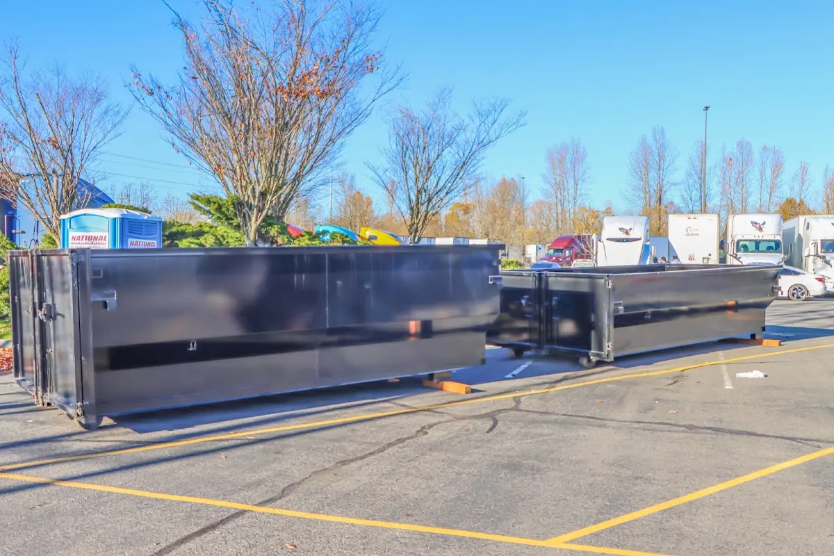 Professional dumpster rental service with roll-off container on residential driveway in Maine